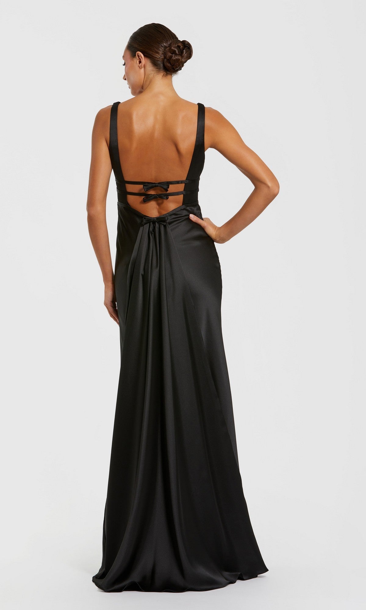Woman in the Raspberry Long Satin Prom Dress (Mac Duggal 68855) with a strappy back and bow detail, posing with one hand on her hip against a plain white background.
